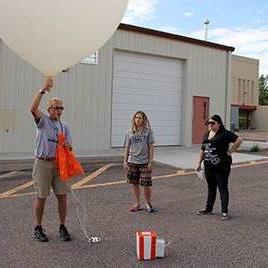 Image of Professor and Students with Balloon. 